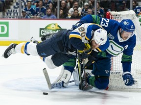 Alex Edler hauls down Ryan O'Reilly of the St. Louis Blues at Rogers Arena on November 5, 2019 in Vancouver, Canada.