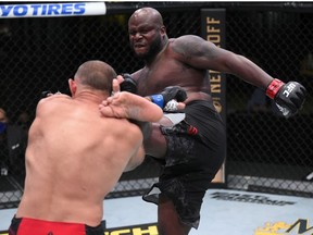 In this handout photo provided by UFC, (R-L) Derrick Lewis kicks Aleksei Oleinik of Russia in their heavyweight fight during the UFC Fight Night event at UFC APEX on August 08, 2020 in Las Vegas, Nevada.