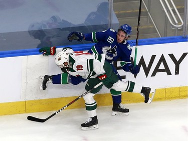 Luke Kunin #19 of the Minnesota Wild collides with Troy Stecher #51 of the Vancouver Canucks in the first period in Game One of the Western Conference Qualification Round prior to the 2020 NHL Stanley Cup Playoffs at Rogers Place on August 02, 2020 in Edmonton, Alberta, Canada.
