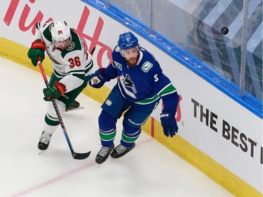 Oscar Fantenberg #5 of the Vancouver Canucks and Mats Zuccarello #36 of the Minnesota Wild pursue the puck in Game 2.