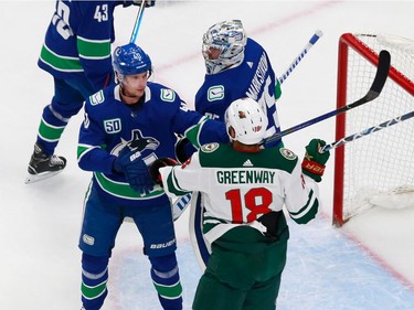 Elias Pettersson of the Vancouver Canucks and Jordan Greenway of the Minnesota Wild mix it up in Game 2.