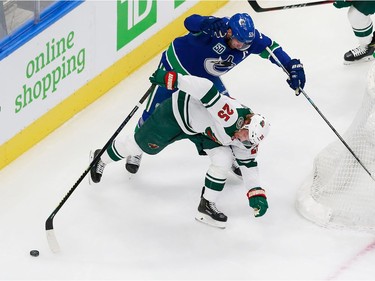 Bo Horvat #53 of the Vancouver Canucks and Jonas Brodin #25 of the Minnesota Wild battle for the puck in Game 2.