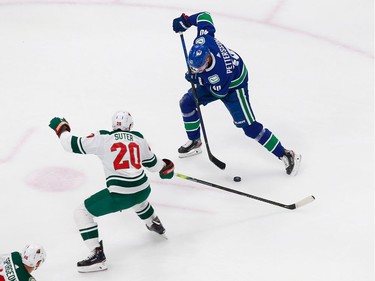 Elias Pettersson #40 of the Vancouver Canucks plays the puck against Ryan Suter #20 of the Minnesota Wild in Game 2.