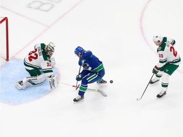 Alex Stalock #32 of the Minnesota Wild makes a sticks save against Brock Boeser #6 of the Vancouver Canucks in Game 2.