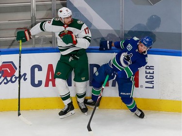 Troy Stecher #51 of the Vancouver Canucks and Brad Hunt #77 of the Minnesota Wild crash into the boards in Game 2.