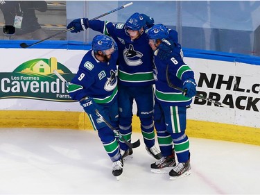 Brock Boeser #6 of the Vancouver Canucks celebrates his second period goal with J.T. Miller #9 and Elias Pettersson #40 in Game 2.