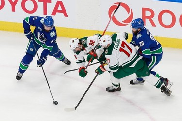 Oscar Fantenberg #5 of the Vancouver Canucks plays the puck as Mats Zuccarello #36 of the Minnesota Wild is tripped up in Game 2.