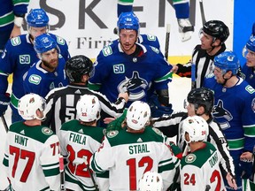 Jay Beagle of the Vancouver Canucks exchanges words with Eric Staal of the Minnesota Wild during a Game 2 scrum at Rogers Place in Edmonton on Tuesday night.