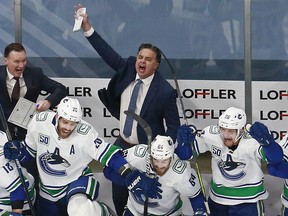Coach Travis Green of the Vancouver Canucks celebrates his team's 5-4 overtime win to beat the Minnesota Wild in Game 4 of the Western Conference qualifying round on Aug. 7 at Rogers Place in Edmonton.