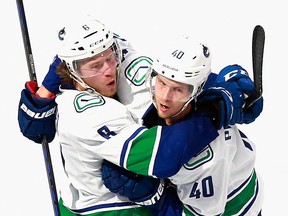 Elias Pettersson of the Vancouver Canucks celebrates his power-play goal against the St. Louis Blues and is grabbed by Brock Boeser (left) in Game One of the Western Conference First Round during the 2020 NHL Stanley Cup Playoffs at Rogers Place on August 12, 2020 in Edmonton.