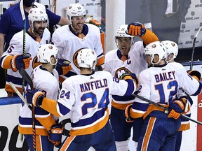 Captain Anders Lee of the New York Islanders (hand raised) is congratulated by his teammates after scoring an empty-net goal against the Washington Capitals in the third period of Game 2 of their NHL Eastern Conference first-round series at Scotiabank Arena in Toronto on Aug. 14, 2020.