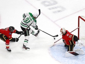 Calgary Flames goalie Cam Talbot stops Dallas Stars forward Tyler Seguin while Flames blueliner TJ Brodie gets his stick up during Game 3 of their NHL Western Conference first-round playoff series at Rogers Place in Edmonton on Aug. 14, 2020.