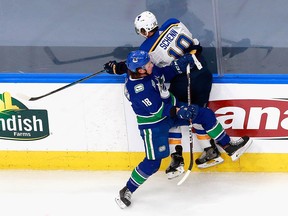 Brayden Schenn of the St. Louis Blues is checked by Jake Virtanen of the Vancouver Canucks in the first period in Game 4.