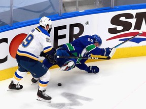 Canucks captain Bo Horvat is upended by Vince Dunn of the St. Louis Blues in the first period, drawing a tripping penalty.