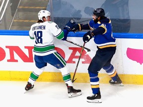 Jake Virtanen of the Vancouver Canucks and Robert Bortuzzo of the St. Louis Blues battle for the puck during the first period in Game Five of the Western Conference First Round during the 2020 NHL Stanley Cup Playoffs at Rogers Place on August 19, 2020 in Edmonton.