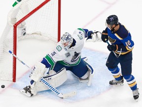Vancouver Canucks goalie Jacob Markstrom makes a third-period save as centre Brayden Schenn of the St. Louis Blues looks for a rebound in Game 5 of their NHL Western Conference first-round series at Rogers Place in Edmonton on Aug. 19, 2020.