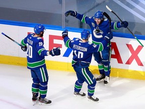 Defenceman Troy Stecher greets teammates Brandon Sutter and Elias Pettersson after scoring in the second period of Game 6 of their NHL Western Conference first-round playoff series against the St. Louis Blues at Rogers Place in Edmonton on Aug. 21, 2020.