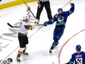Elias Pettersson of the Vancouver Canucks gets rocked back by Brayden McNabb of the Vegas Golden Knights during Game 3 of the Canucks-Golden Knights second-round NHL Western Conference series at Rogers Place in Edmonton on Saturday.