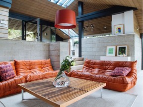 The Ligne Roset "Togo" sofas, designed in 1971, complement the mid-century design of the heritage Ron Thom-designed home on Duchess Avenue in West Vancouver, updated by Livingspace Homes.