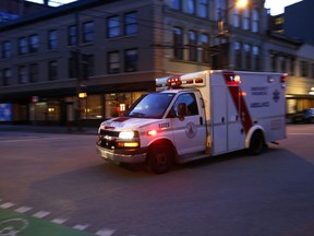 An ambulance drives through downtown Vancouver.