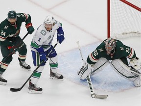 Vancouver Canucks forward Brock Boeser, centre, looks for a rebound in front of Minnesota Wild goaltender Alex Stalock during Thursday's NHL action at Rogers Place in Edmonton. The Canucks lead the best-of-five qualifying series 2-1.