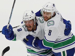 Canucks defensemen Chris Tanev (right) celebrates with J.T. Miller after Tanev scored the series winning goal against the Minnesota Wild.