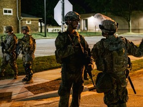 National Guard troops stand inside a fenced area that surrounds several government buildings on August 27, 2020 in Kenosha, Wisconsin.