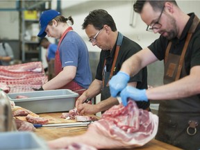 Meat cutter Jim Buchholz (centre) at Beefway Meats on Kingsway in Vancouver.