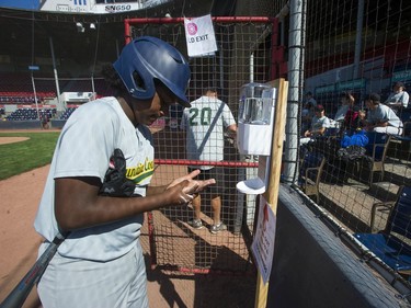 Under-15 baseball game at Nat Bailey Stadium Saturday, August 29, 2020 between Sunshine Coast and West Van. It's a rare event in the times of Covid-19, but with safety protocols in effect the game is played with those measures in mind, albeit with no fans. Pictured is Sunshine Coast player Joshua Warren using hand sanitizer.