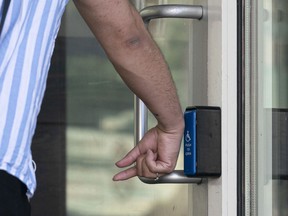 A person uses the back of their hand to press the accessibility button on a door in Vancouver this week. ‘I would really appreciate it if people used their elbows, hips or literally any other part of their body to press those buttons — just not your feet,’ says a wheelchair user.
