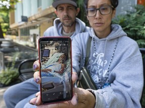 Alicia Chonn holds up a picture of her daughter Nevaya who is at Children's Hospital after she was seriously injured in an ATV crash. Chonn's partner Dana Williams sits next to her.