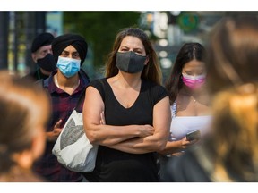 People wear masks to protect against COVID-19 on the streets of downtown Vancouver.