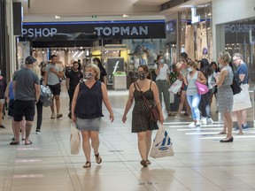 Shoppers walk through a mall in Quebec in June.