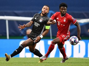 Olympique Lyonnais' Memphis Depay battles with Bayern Munich's Alphonso Davies in their Champions League semi final on August. 19, 2020.