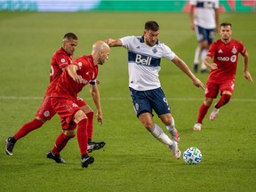 Vancouver Whitecaps forward Lucas Cavallini moves the ball against Toronto FC midfielder Michael Bradley (4) at BMO Field on Tuesday.