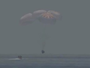 A capsule with NASA astronauts Robert Behnken and Douglas Hurley splashes down in the Gulf of Mexico, August 2, 2020, in this screen grab taken from a video.