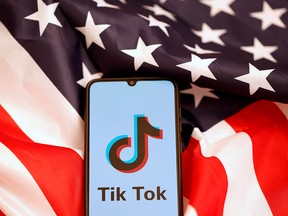 The Tik Tok logo is displayed on the smartphone while standing on the U.S. flag in this illustration picture taken, Nov. 8, 2019.