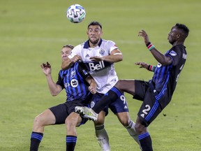 Canadian striker Lucas Cavallini, here squeezing between a pair of Montreal Impact players last season, was clearly starved of service in 2020. Hence the Whitecaps’ search for a creative, attacking midfielder.