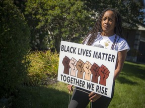 Wendy Knight Agard stands beside the Black Lives Matter sign outside her home in Stittsville on Saturday.