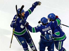 Quinn Hughes gets a hug after scoring in the third period Thursday.