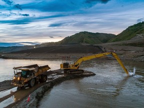 An excavator dredging out a channel at the entrance to one of the river diversion tunnels on B.C. Hydro's Site C dam project on the Peace River near Fort St. John, in August of 2020.