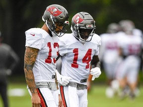 Wide receivers Chris Godwin (right) and Mike Evans of the Tampa Bay Buccaneers talk things over during training camp at the AdventHealth Training Center last month.