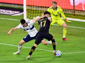 Vancouver Whitecaps keeper Bryan Meredith faces down Los Angeles FC midfielder Brian Rodriguez  as he moves past defender Cristian Gutierrez  during the first half at Banc Of California Stadium on Wednesday.