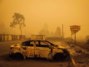 A charred vehicle is seen in the parking lot of the burned Oak Park Motel after the passage of the Santiam Fire in Gates, Ore., on Sept. 10, 2020.