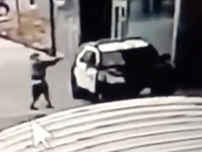 A man aims at a police vehicle in Compton, California, September 12, 2020 in this still image taken from a video tweeted by the LASD.