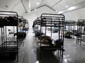 People sleep in socially distanced beds in a sprung structure at the Union Rescue Mission homeless shelter amid the COVID-19 pandemic in Los Angeles on Sept. 16.