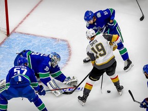 Canucks goalie Thatcher Demko makes a save on a shot by Vegas Golden Knights right wing Reilly Smith as Troy Stecher defends during the second period in Game 6.