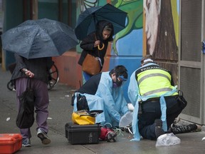 Paramedics help a man suffering a drug overdose on Columbia Street in Vancouver's Downtown Eastside May 2, 2020. After being injected with Naloxone by the paramedics the man woke up and walked away.