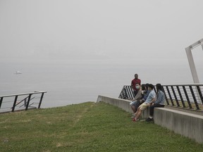 People take a seat in Coal Harbour on Saturday afternoon, Sept. 12, 2020, looking out to Burrard Inlet.