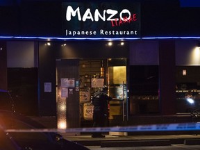 A police officer enters Manzo Japanese Restaurant where two people were shot at in Richmond on the night of Sept. 18.